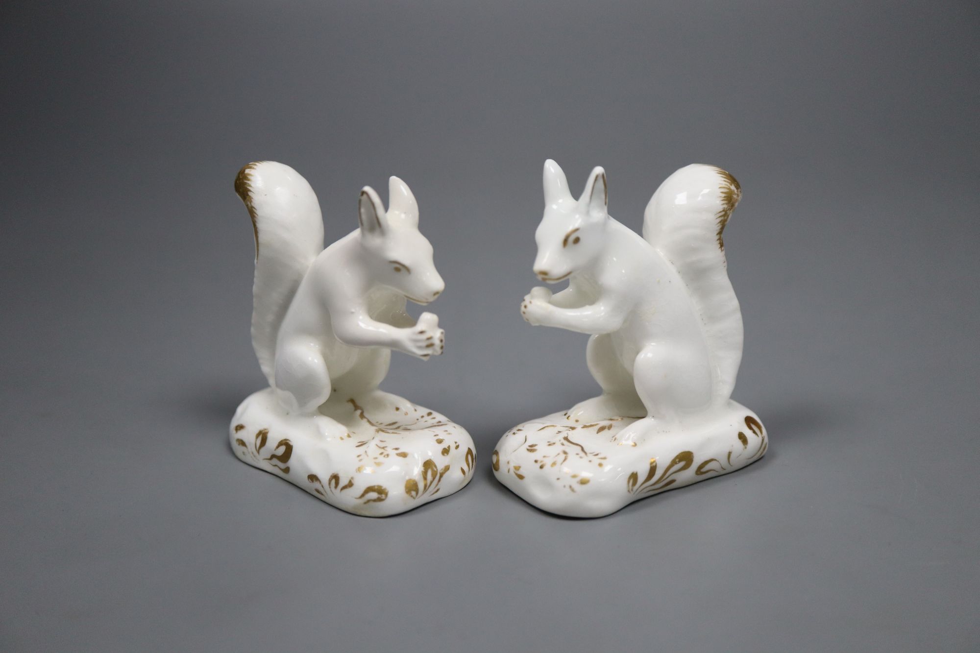 A pair of Grainger, Lee & Co. gilt and white porcelain figures of squirrels, c.1820-37, 6.5cm high